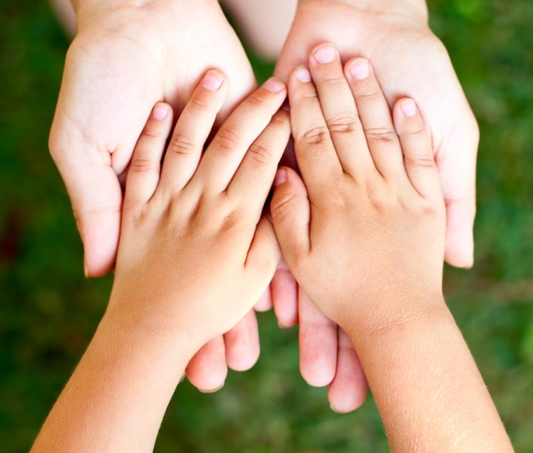 Child's hand in adult's hand , supporting children